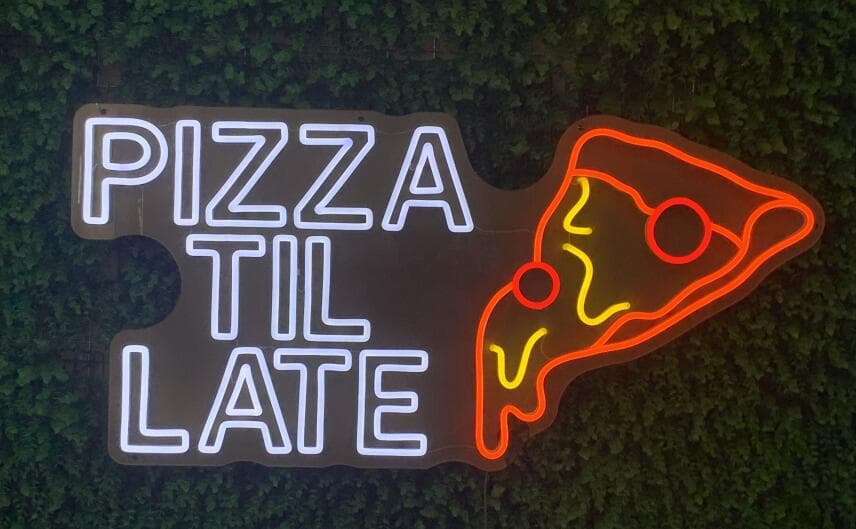 White neon words Pizza Til Late beside an orange pizza slice